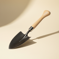 Forged steel garden spade on a warm off-white studio background