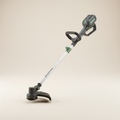 Compact cordless string trimmer on a warm off-white studio background